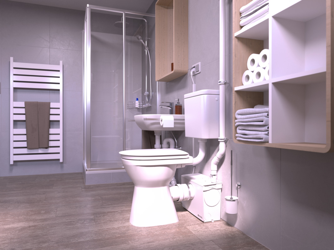 A close-up of a toilet, behind which stands a small lifting station to which a shower is also connected.