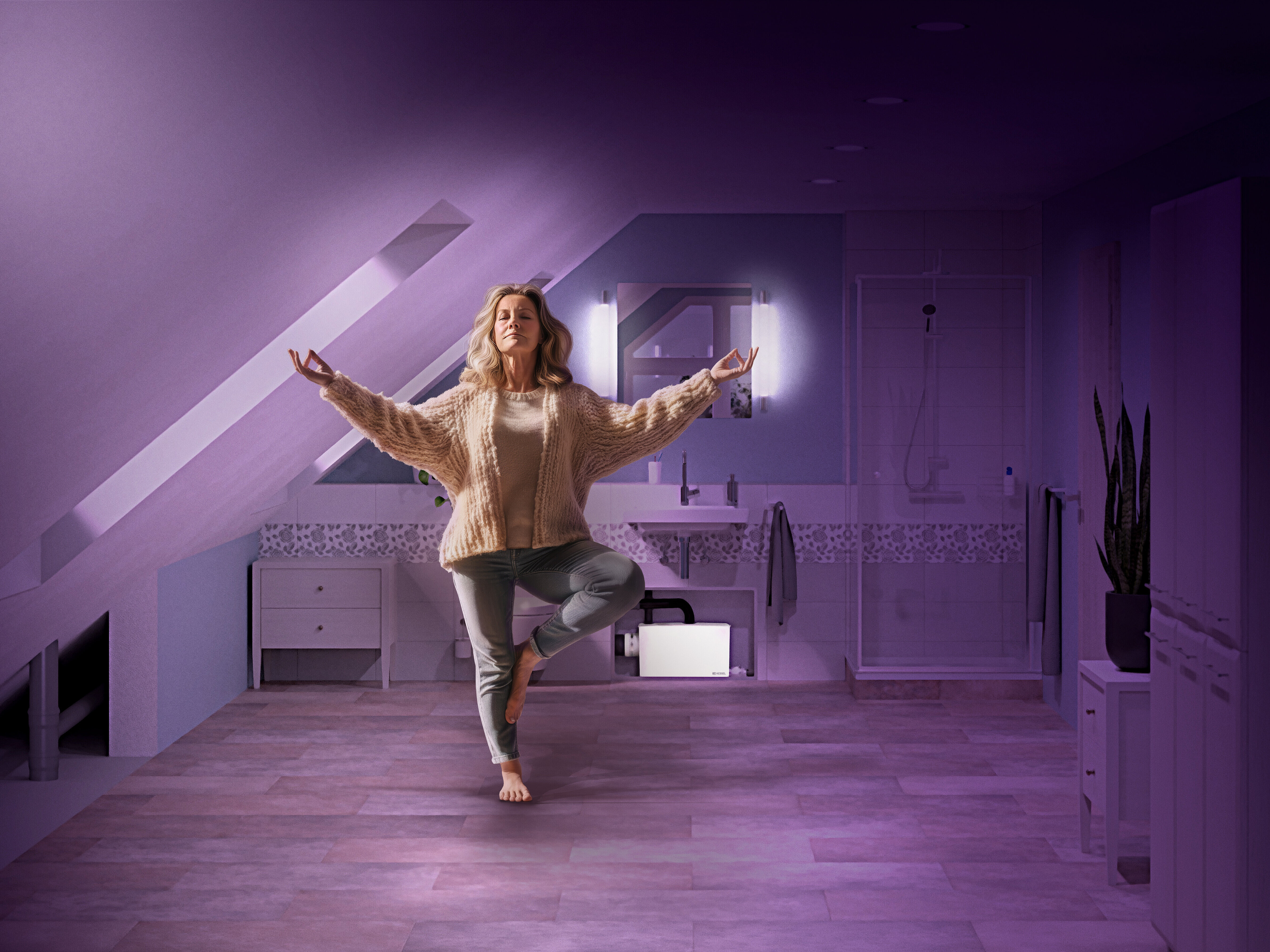 So compact that it fits under any sink A woman is doing yoga in the bathroom; in the background, a small lifting station has been installed to save space and blend in with the surroundings.