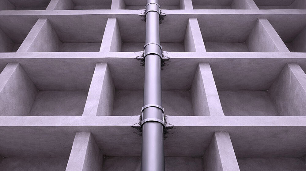 A schematic diagram of a pipe running upwards through several floor slabs.